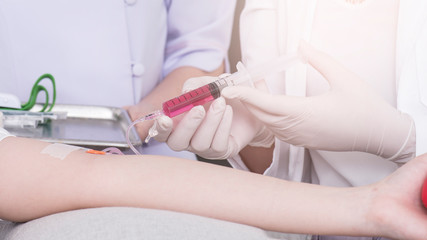 close up of a young women have needle injection vitamins and minerals directly into bloodstream in clinic