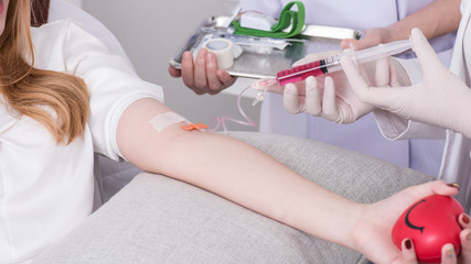 close up of a young women have needle injection vitamins and minerals directly into bloodstream in clinic