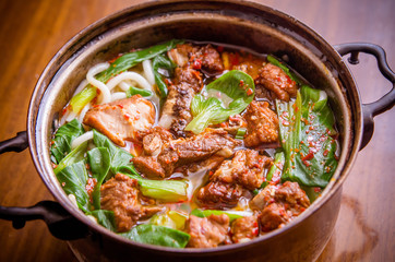 The delicious meat noodles in an old iron pot. This is traditional chinese cuisine, and it is very healthy,beacause it contains protein, vegetable, carbohydrate and many other important substances.