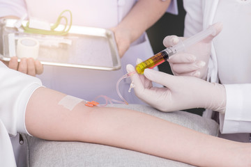 close up of a young women have needle injection vitamins and minerals directly into bloodstream in clinic