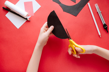 How to make bat out of paper at home. Hands making craft out of paper. Step by step photo instruction. Step 3. Cut the circles into two parts. Children DIY art project