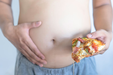 Fat man with piece of pizza in hand. Unhealthy Lifestyle, Unhealthy concept