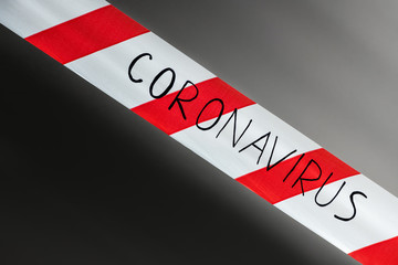 Label coronavirus. Red and white warning tape with the inscription coronavirus close up on black...