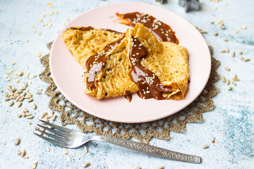 Folded crepes thin pancakes with chocolate sweet spread syrup.