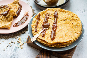 Folded crepes thin pancakes with chocolate sweet spread syrup.