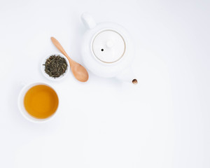 cup with tea and teapot on white background, over light

