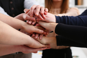 Group of people in suits crossed hands in pile for win closeup. White collar leadership high five cooperation initiative achievement corporate life style friendship deal heap stack concept