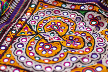 embroidered good like old handmade cross-stitch ethnic Indian pattern,embroidery design and pattern art with colorful handmade fabric,embroidery ethnic flowers neck line flower design ,selective focus