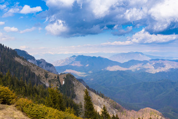 Spring mountain scenery in the Alps, wih snow covered ridges and clouds