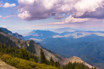 Fototapeta premium Spring mountain scenery in the Alps, wih snow covered ridges and clouds