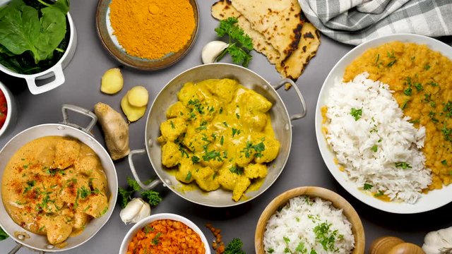 assorted of Indian food, curry chicken, rice, naan, lentil Dahl