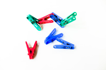 Many different colored plastic clothes pegs isolated on white background.