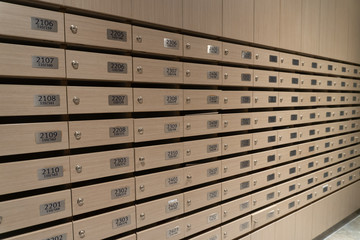 So many the mailboxes brown wood texture were placed on first in a condominium at the lobby of a high rise building for information, letter and news.