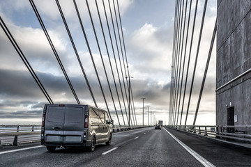 A black van driving over the Øresund Bridge between Sweden and Denmark