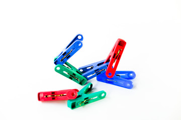 Many different colored plastic clothes pegs isolated on white background.