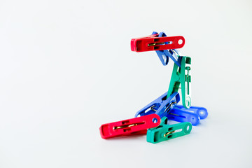 Many different colored plastic clothes pegs isolated on white background.