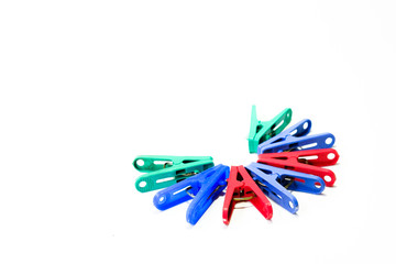 Many different colored plastic clothes pegs isolated on white background.