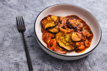 plant-based food, vegan aubergine zucchini bake with tomatos and nutritional yeast topping