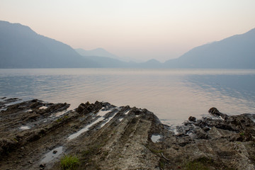 reflective mountain lakes with rippled muddy bank