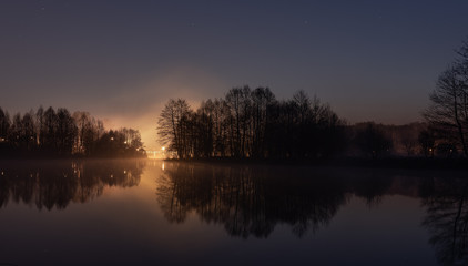 Obraz premium Wschód słońca nad rzeką Pilicą. Na przełomie niebieskiej i złotej godziny. W oddali most nad rzeką.