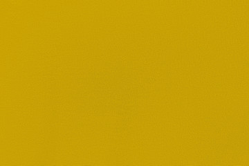 Mustard color homogeneous background with a textured surface. Gray fabric.