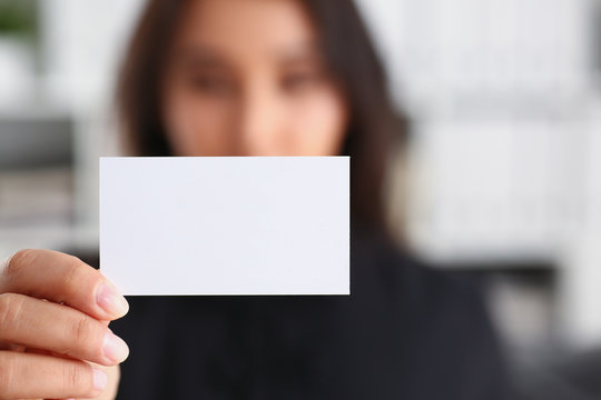 portrait of young beautiful brunette chinese businesswoman work in office show cutaway business card
