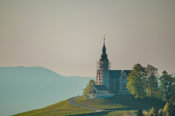 Small picturesque church in Crni Vrh, Slovenia, during early morning hours at sunrise. The bell...