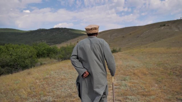 Behind. Mountains Of Afghanistan. Old Pashtun man walks through a desolate area