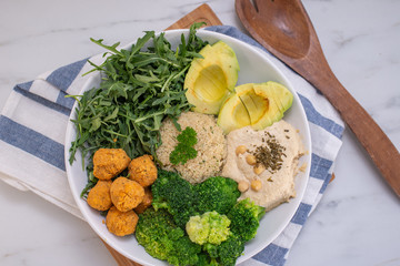 Vegan lunch bowl with quinoa, hummus, chickpeas, avocado, vegetables