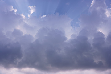 white and gray cloudy sky with bright aura ray of sun beam under deep blue sky ; strom comming