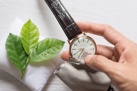 Close up cleaning modern watch with microfiber cloth and Cleaner cream concept.Cleaning modern watch by Cleaner cream.Cleaning stainless steel by Cleaner cream,Cleaning leather by Cleaner cream,