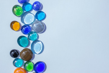 Abstract art design background of colorful glass drop dragon tears on a light blue background with copy space