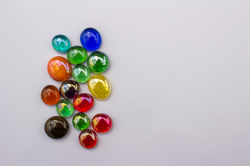 Abstract art design background of colorful glass drop dragon tears on a light neutral background with copy space