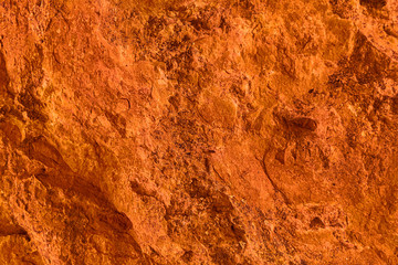 Vivid orange textured background and wallpaper, natural surface of rock formation