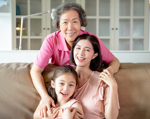 happy grandmother and daughter with granddaughter at home