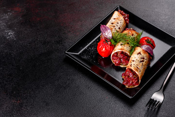 Delicious fresh beef tartar with toasts on a black square plate