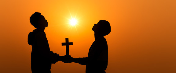 Young christians holding the cross and worship in morning time with sun light background,...