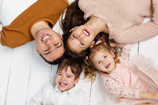 Happy family having fun together at home. Family 
happy relationship concept. Stay home. Isolation together. Cozy home. Portrait of kids and parents spending time together lying on the floor at home