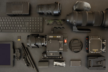 Flat lay of filming equipment with keyboard and eyeglasses on table