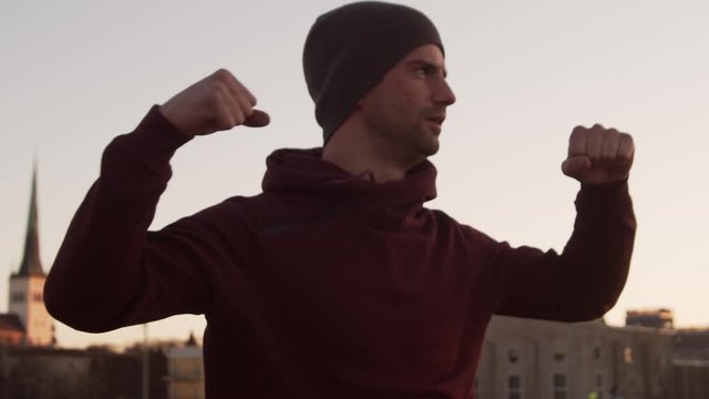 Young man having evening training outdoor. Urban sunset background. Fitness and sport.