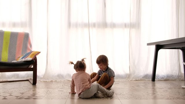 Little girl playing with brother at home