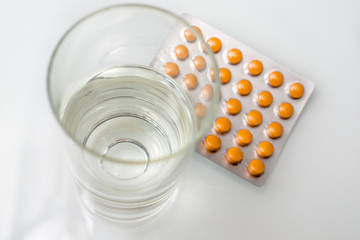 A package of orange tablets is placed on a white background
