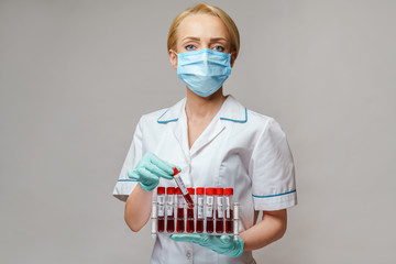 medical doctor nurse woman wearing protective mask and gloves - holding rack with virus blood tests