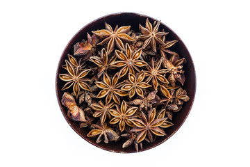 star anise in wooden bowl on white background.