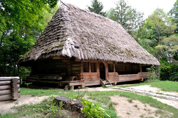 Plakat Traditional ukrainian village house. Wooden house with thatched roof in the countryside.