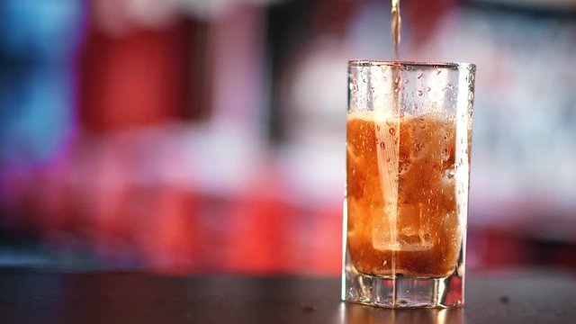 Flowing soda drinking with foam and bubble in glassful slowmo. Shot on RED Raven 4k Cinema Camera