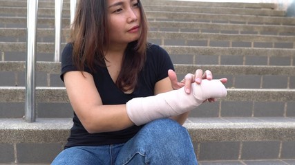A beautiful Asian girl broke her arm and splinted,Woman accidentally falls, arms hit the ground, causing fractures,	