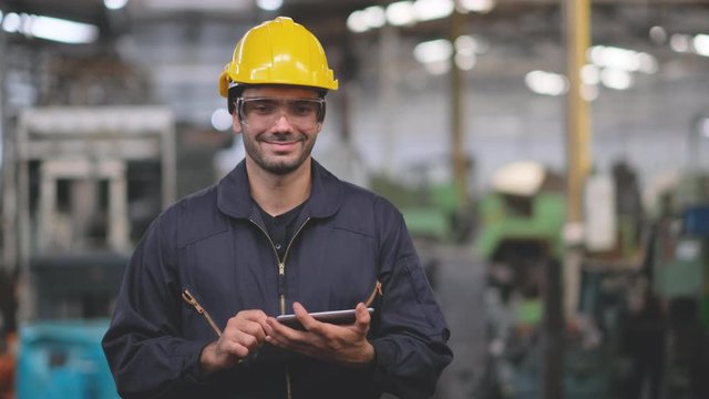 Smart engineer or technician use tablet then smile to camera in the factory with concept happy of work.
