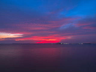 A cargo ship is sailing in the Gulf of Thailand in the twilight  hour.