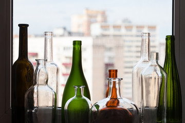 various empty bottles on sill and view of city